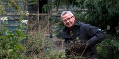 Cover van het boek Van madeliefje tot Sequoiadendron, tuinchef Eddy Avanture poseert met tuingereedschap in de hand tussen de bloeiende herfstborders in de tuin van Arboretum Kalmthout.